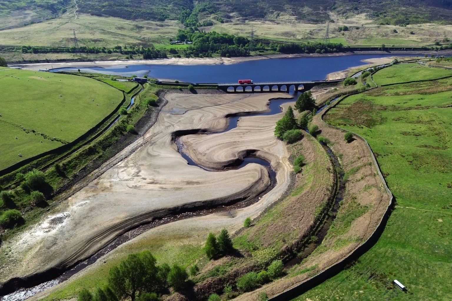epa12095831 An aerial photograph taken with a drone shows the partially revealed bed of Woodhead Reservoir in Derbyshire, Britain, 13 May 2025. The UK Environment Agency has warned of the risk of a su ...