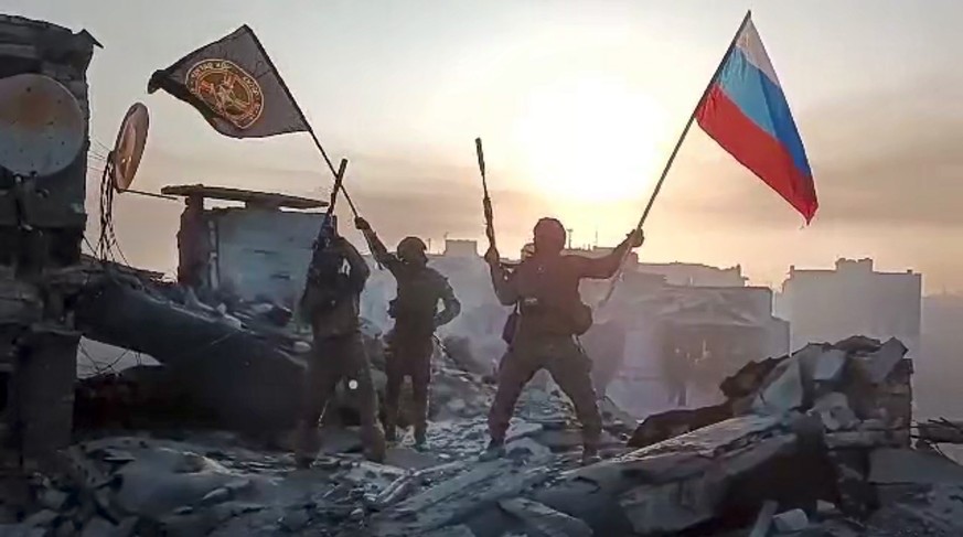 In this grab taken from video released by Prigozhin Press Service on Saturday, May 20, 2023, Yevgeny Prigozhin&#039;s Wagner Group military company members wave a Russian national and Wagner flag atop ...