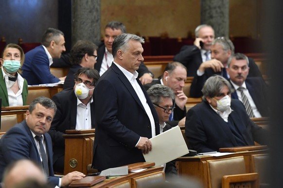 epa08332120 Hungarian Prime Minister Viktor Orban (C) arrives for the plenary session of the Parliament in Budapest, Hungary, 30 March 2020. Reports state MPs approved legislation that extends a state ...