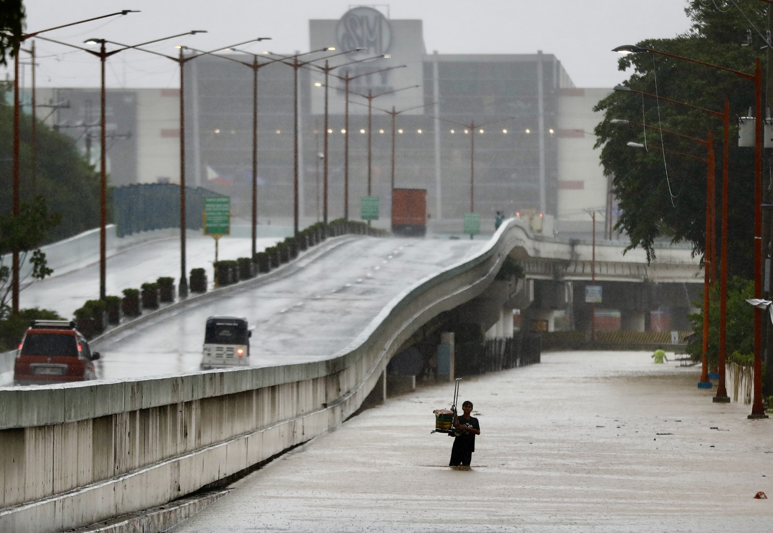 epa11493420 A resident wades on rising floodwaters in Marikina city, Metro Manila, Philippines, 24 July 2024. Interior and Local Government Secretary Benhur Abalos Junior recommended on 24 July the de ...