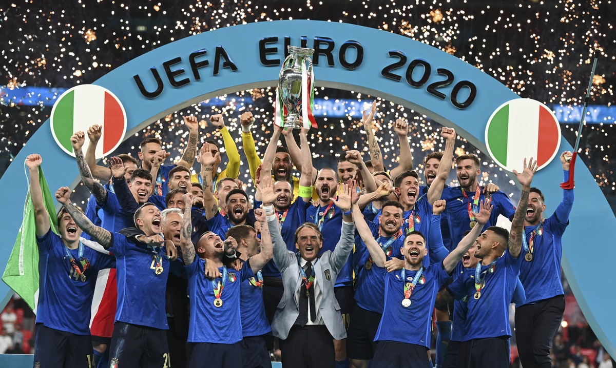FILE - Italy's team celebrates with the trophy on the podium after winning the Euro 2020 soccer championship final between England and Italy at Wembley stadium in London, Sunday, July 11, 2021. I ...