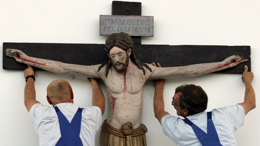 Workers suspend the 1100-year-old crucifix from the church of the village of Enghausen, Bavaria, above the altar on the fair grounds in Munich, southern Germany, Thursday, Sept. 7, 2006, where pope Be ...