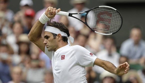 Switzerland&#039;s Roger Federer returns the ball to Slovakia&#039;s Lukas Lacko during their men&#039;s singles match, on the third day of the Wimbledon Tennis Championships in London, Wednesday July ...