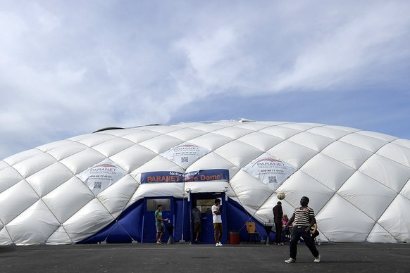 Migranten spielen vor dem Notfallzelt in München Fussball.