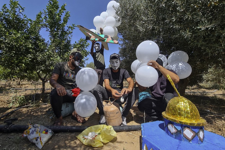 Masked Hamas-affiliated operatives prepare balloons to be launched towards Israel, next to the eastern border of Gaza Strip, Saturday, Sept. 4, 2021. Gaza&#039;s ruling Hamas militant group on Saturda ...