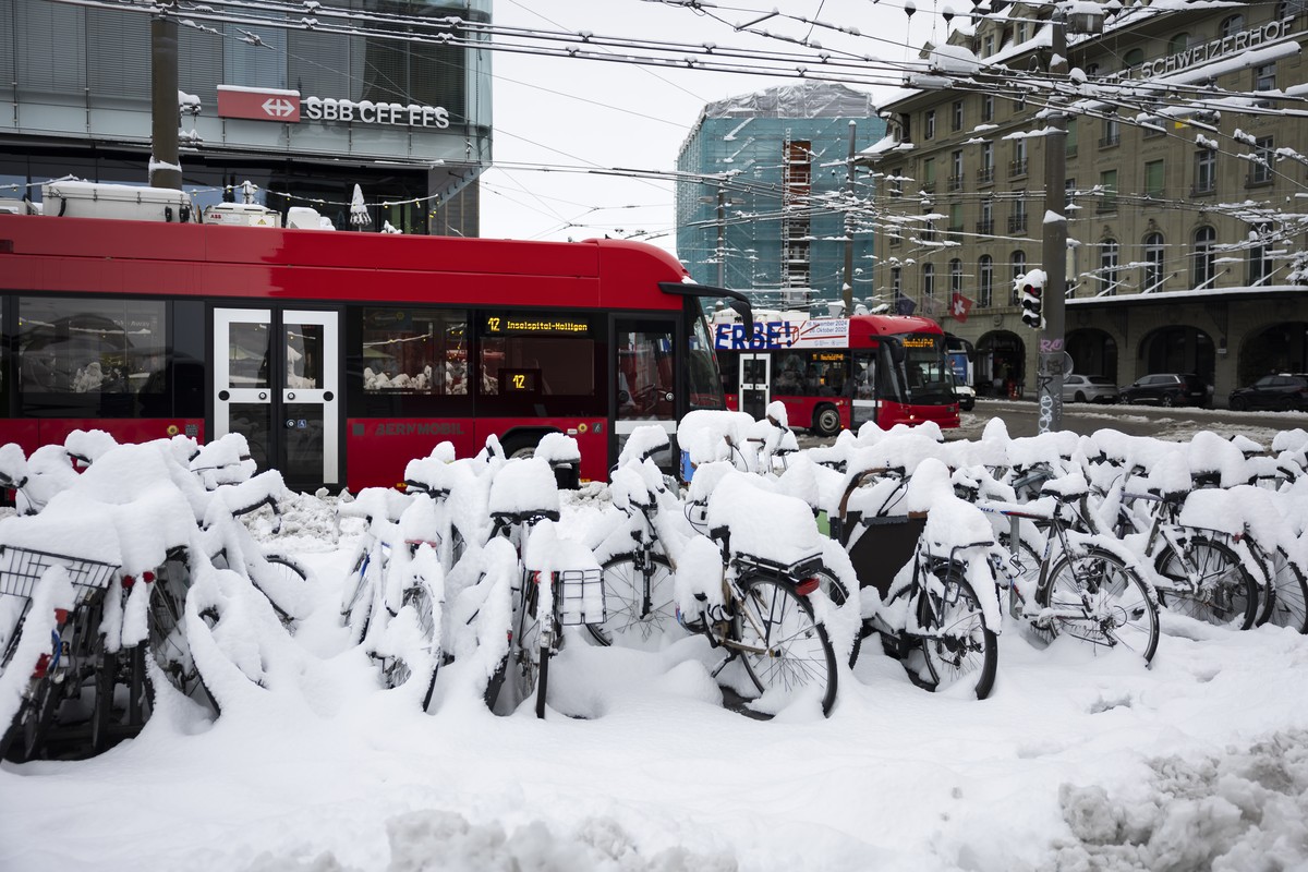 Busse verkehren beim Bahnhof neben mit Schnee bedeckten Fahrraedern, am Freitag, 22. November 2024 in Bern. Die verbreiteten Schneefaelle vom Vorabend und in der Nacht haben in weiten Teilen des Mitte ...