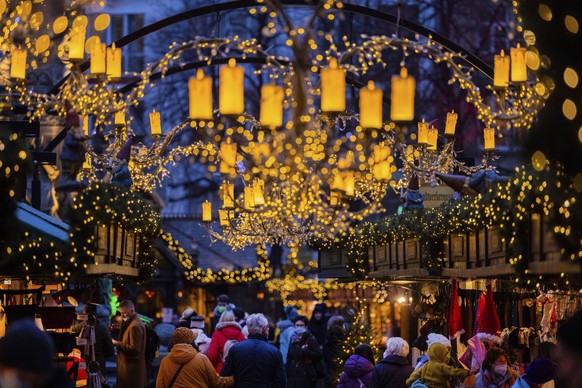 Visitors walk through the Christmas market at Alter Markt, Cologne, Germany, Monday, Nov. 29, 2021. Chancellor Angela Merkel will hold talks Tuesday with the governors of Germany&#039;s 16 states amid ...