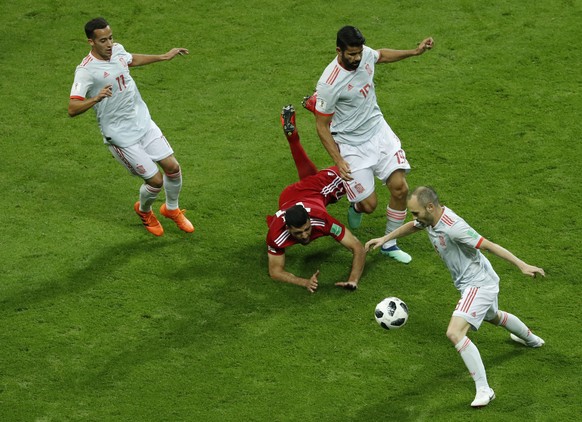 Iran&#039;s Mehdi Taremi, center, clashes with Spain&#039;s Lucas Vazquez, left, and Spain&#039;s Diego Costa, upper right, as Spain&#039;s Andres Iniesta picks up the loose ball, during the group B m ...