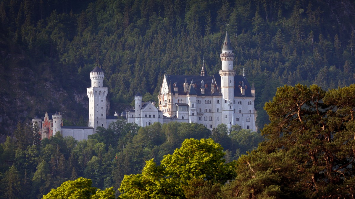 18.06.2023, Bayern, Schwangau: Das Schloss Neuschwanstein im Morgenlicht. Bei einem B