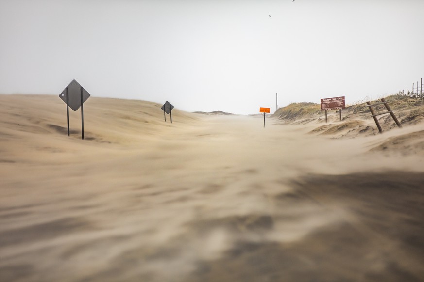 epa07824189 North Carolina Highway 12 is obscured in blowing sand as Hurricane Dorian hits the Cape Hatteras National Seashore, North Carolina, USA, 06 September 2019. The Category 1 storm struck the  ...