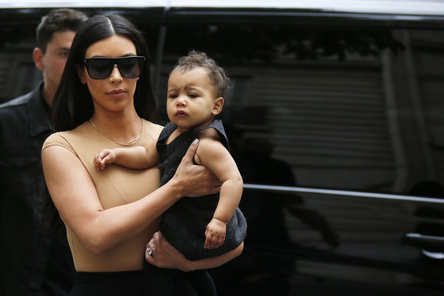 TV personality Kim Kardashian holds her daughter North in her arms as she shops in Paris May 20, 2014. U.S. television personality Kim Kardashian and rapper Kanye West will celebrate their wedding in  ...