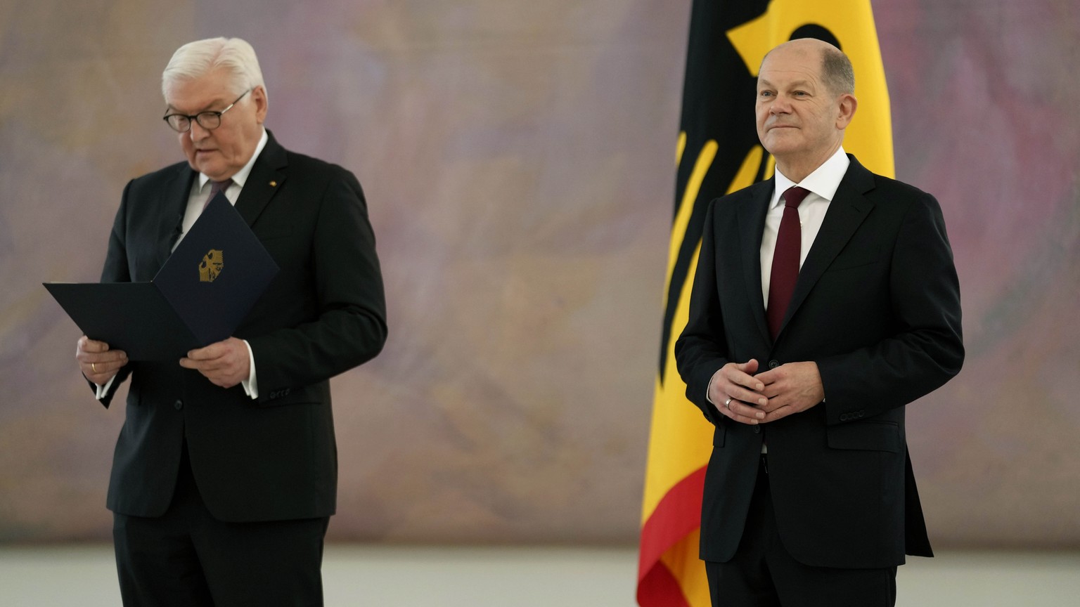 German Chancellor Olaf Scholz, right, looks on as German President Frank-Walter Steinmeier, left, speaks, prior to presenting the letters of appointment to the new German federal ministers during a re ...