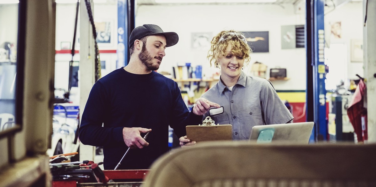 Female, Garage, Blue Collar, Employment, Candid, Engineers, Mechanics - Female mechanic with her colleague at a service station