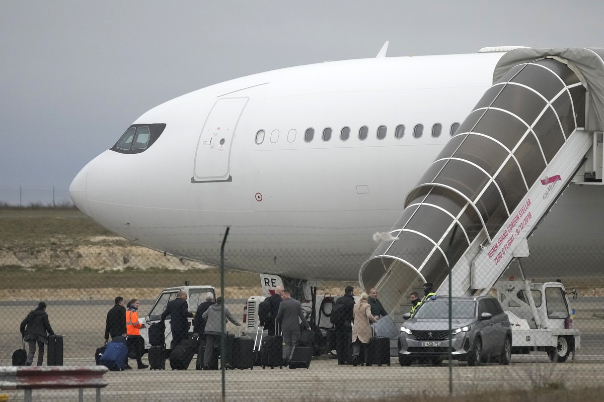 Crew members board the plane grounded by police at the Vatry airport , Monday, Dec. 25, 2023 in Vatry, eastern France. A charter plane grounded in France for a human trafficking investigation is sched ...