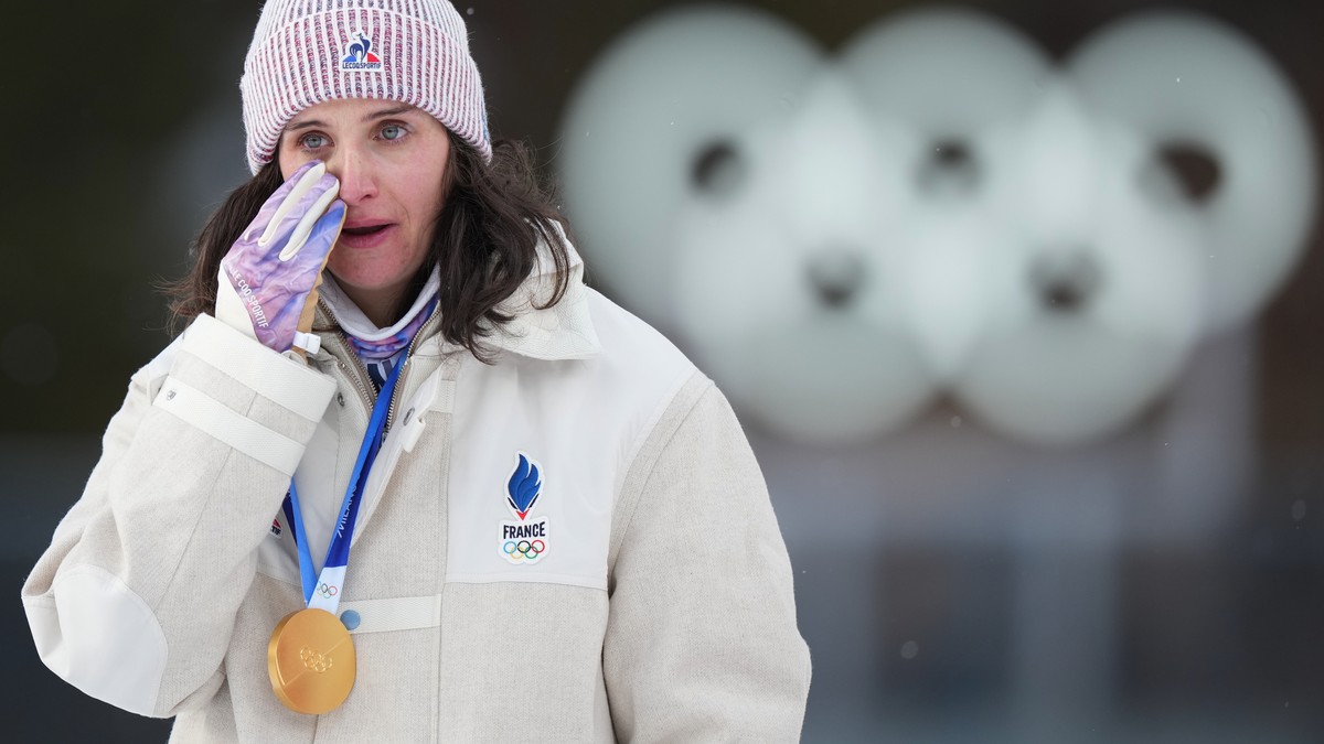 Julia Simon, of France, reacts with the gold medal for the women's 15-kilometer individual biathlon race at the 2026 Winter Olympics in Anterselva, Italy, Wednesday, Feb. 11, 2026. (AP Photo/Andr ...