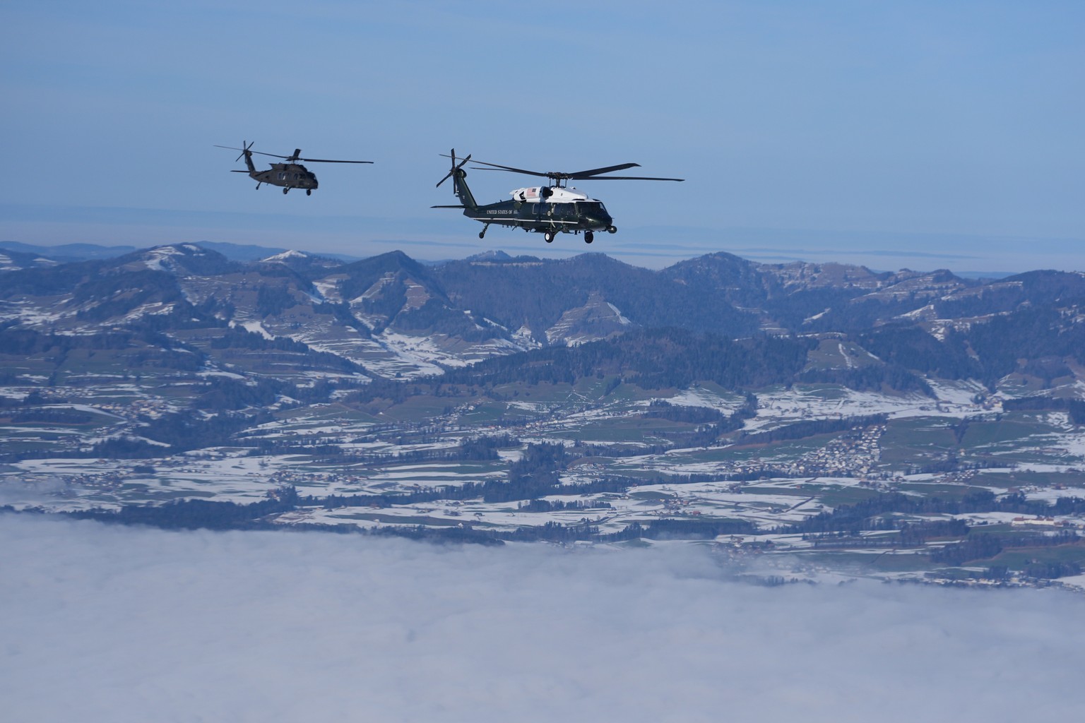 Marine One, carrying President Donald Trump, is escorted by military helicopter during his transfer to Davos after arriving at the airport in Zurich, Switzerland, Wednesday, Jan. 21, 2026. (AP Photo/E ...