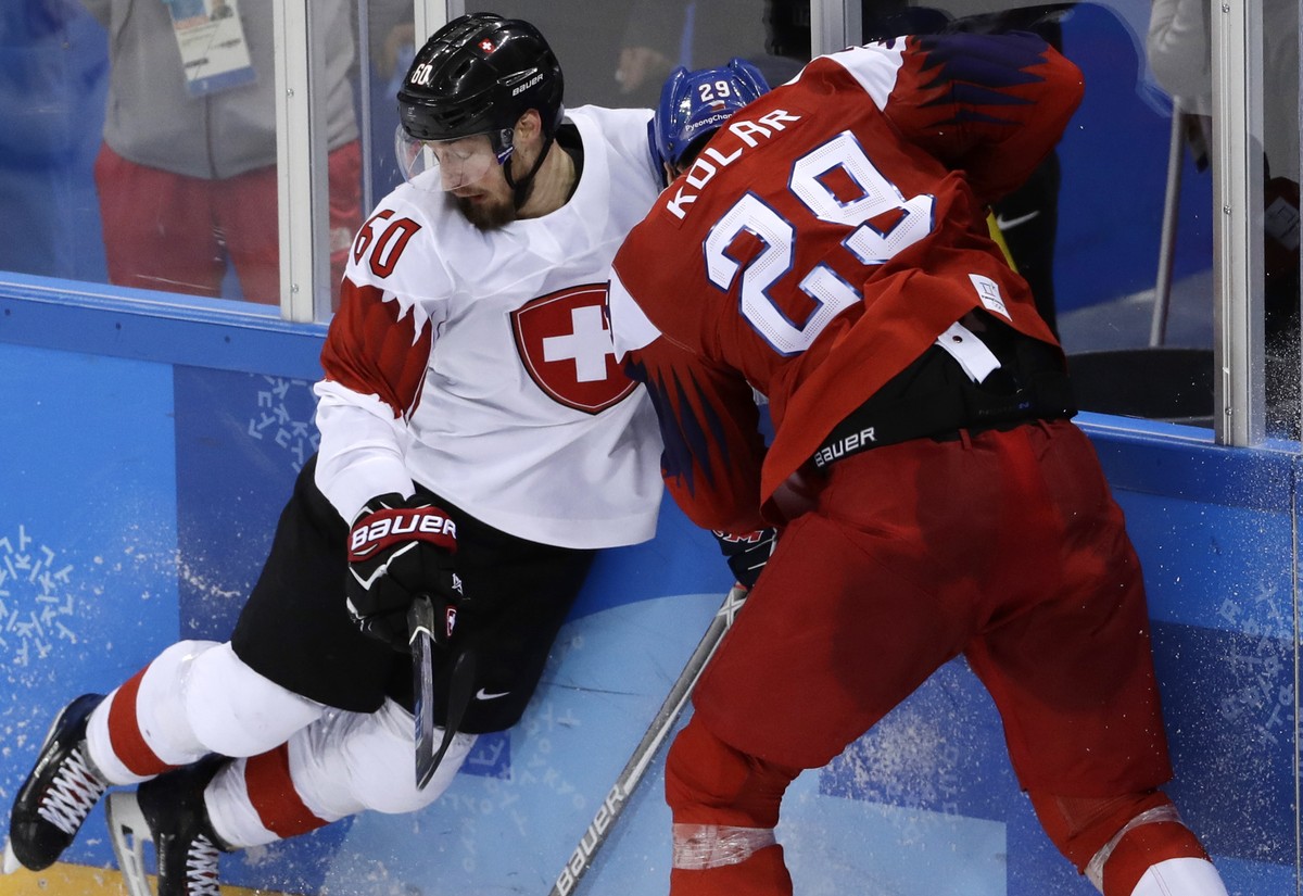 Tristan Scherwey (60), of Switzerland, and Jan Kolar (29), of the Czech Republic, battle for the puck during the third period of the preliminary round of the men's hockey game at the 2018 Winter  ...