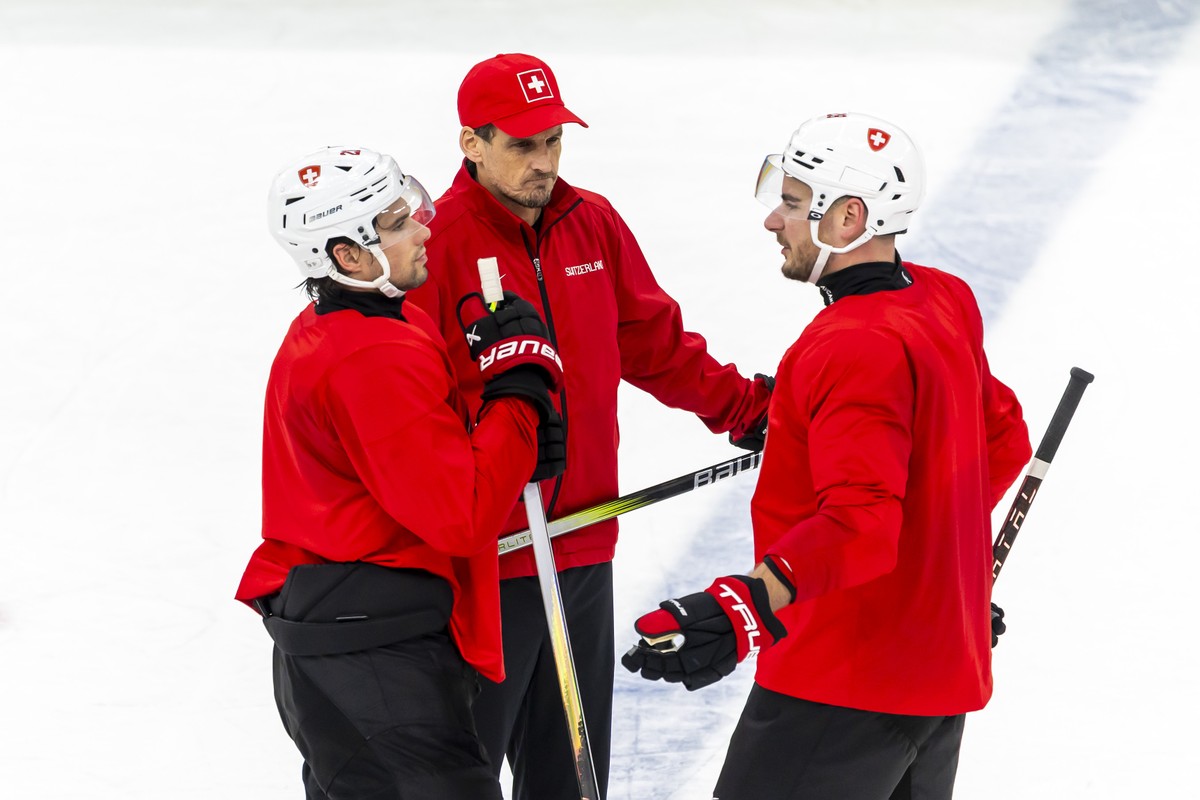 Patrick Fischer, head coach of Switzerland national ice hockey team, speaks with Switzerland's Kevin Fiala, left, and Switzerland's Timo Meier, right, during a training session of team Switz ...