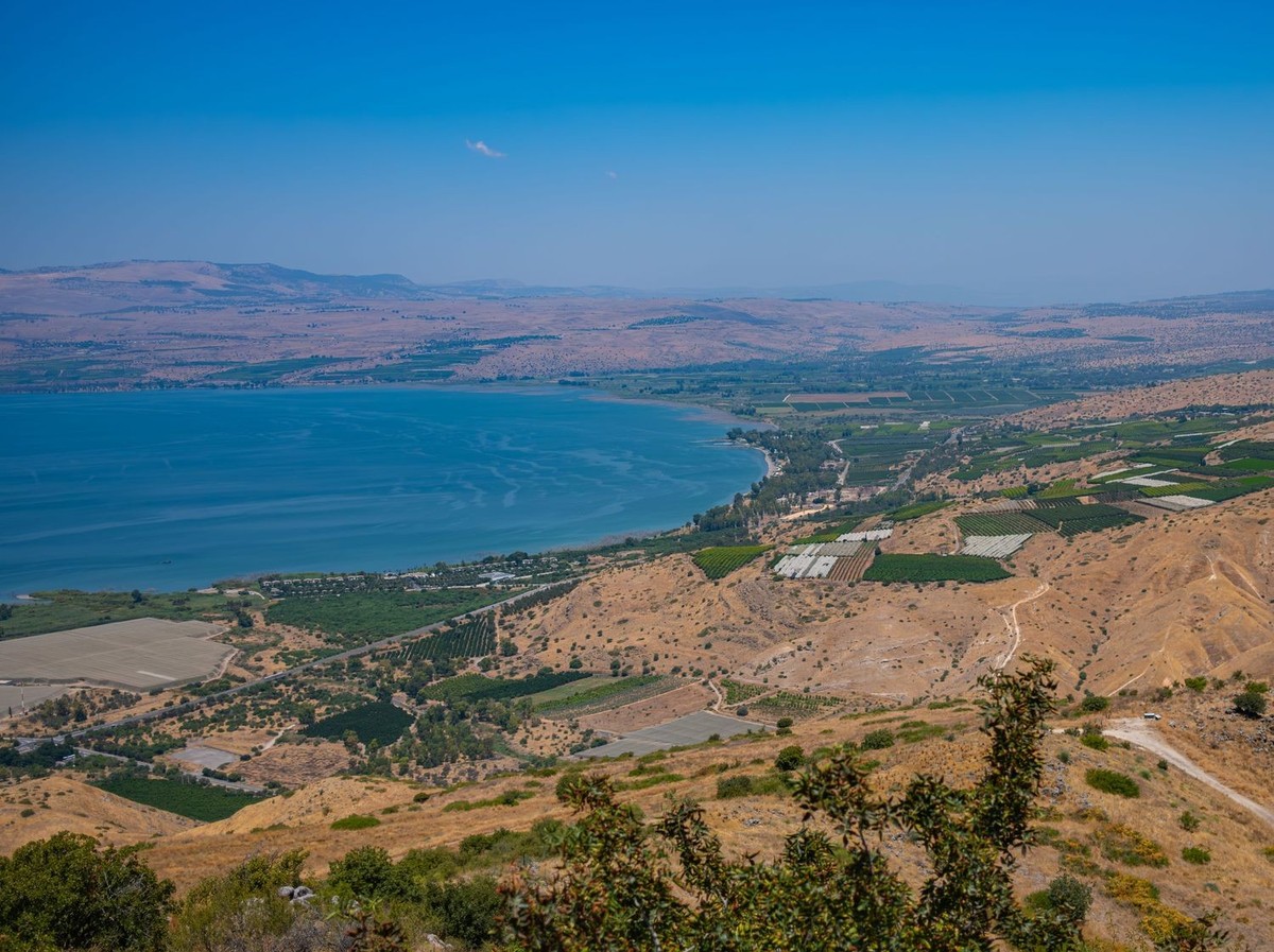 A stunning aerial view of the Sea of Galilee in Israel, framed by lush farmlands and golden hills under a vibrant blue sky. 27723338 RECORD DATE NOT STATED