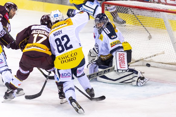 Le joueur tessinois, Michel Ngoy, centre, a la lutte pour le puck avec le joueur Genevois, Arnaud Jacquemet, gauche, devant le gardien tessinois, Benjamin Conz, droite, lors du match du championnat su ...