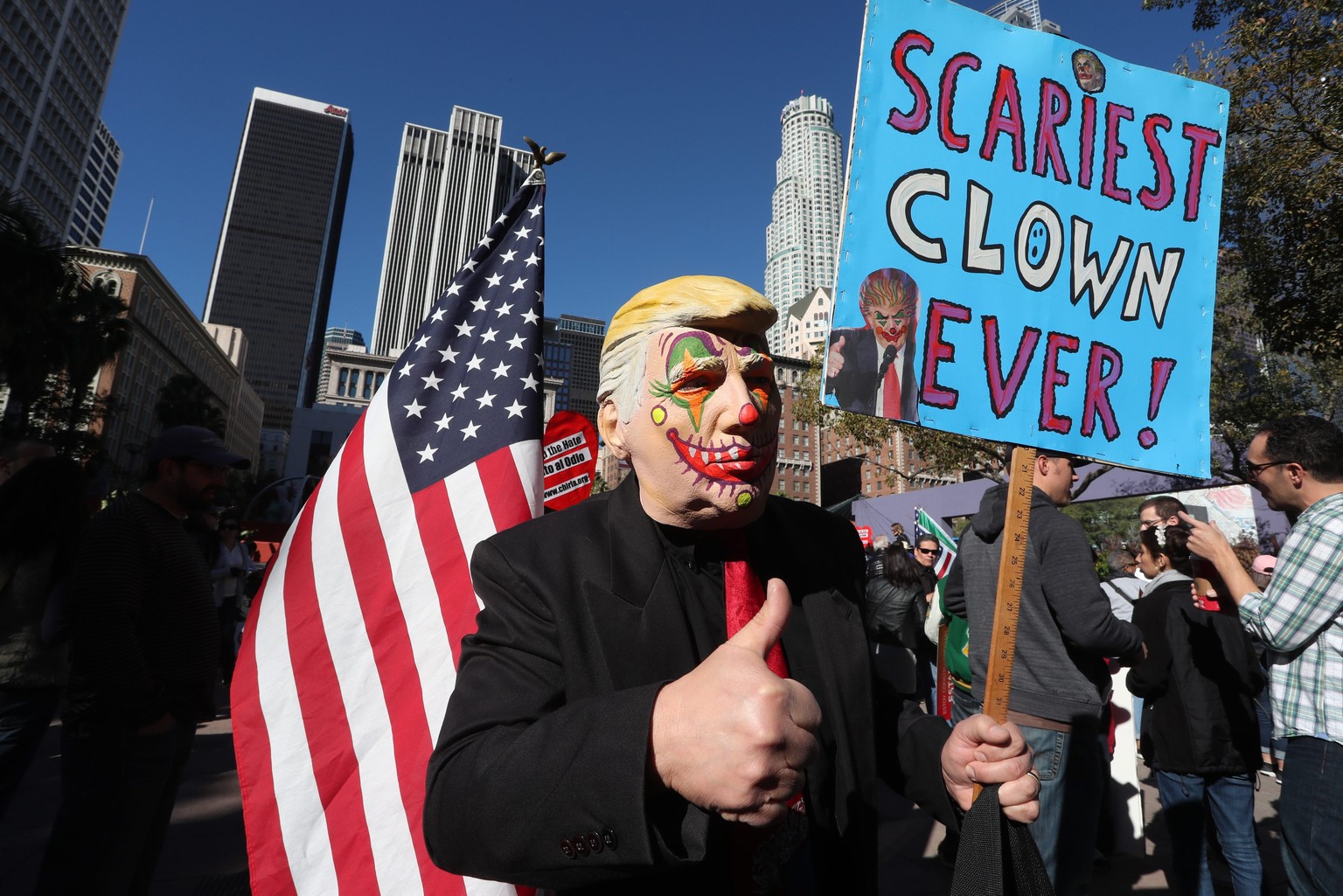 epaselect epa05681731 Rod Rodriguez wearing a Donald Trump clown mask and carrying a sign that reads &#039;Scariest Clown Ever!&#039;, joined over a thousand demonstrators who marched on International ...