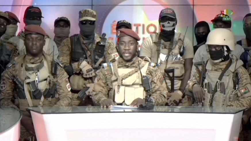 In this image from video broadcast by RTB state television, coup spokesman Capt. Kiswendsida Farouk Azaria Sorgho reads a statement in a studio in Ougadougou, Burkina Faso, on Friday evening, Sept. 30 ...