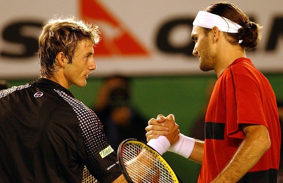 Roger Federer of Switzerland and Juan Carlos Ferrero of Spain shake hands after the semi-finals of the Australian Open in Melbourne, Friday 30 January 2004 . Federer won in straight sets 6-4, 6-1, 6-4 ...