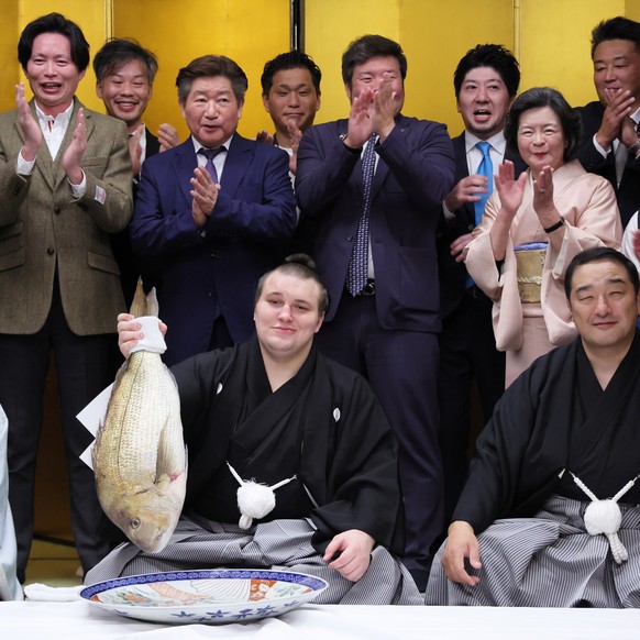 epa12544099 Ukrainian sumo wrestler Aonishiki (C) holds a seabream after he won the Kyushu Grand Sumo Tournament in Fukuoka, southwestern Japan, 23 November 2025. Aonishiki became Ukraine&#039;s first ...
