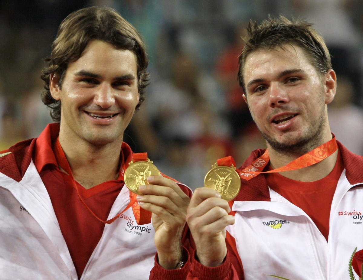 FILE- In this Saturday, Aug. 16, 2008, file photo, Roger Federer, left, and Stanislas Wawrinka of Switzerland celebrate winning the men's tennis doubles gold medal at the Beijing 2008 Olympics in ...