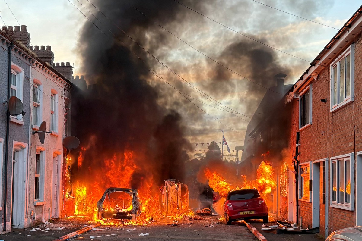 Vehicles set on fire by protesters burn on Lendrick Street in east Belfast, Northern Ireland, on Tuesday, June 9, 2026, after the arrest of a Sudanese man accused of stabbing a man in the northern par ...