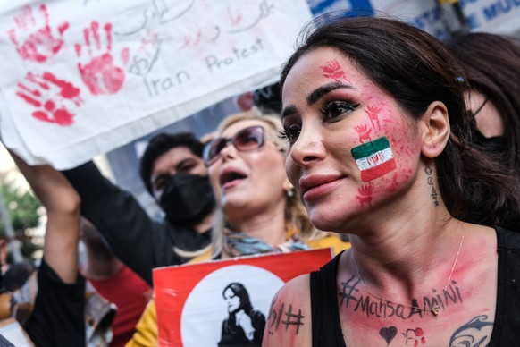 epa10248884 Iranian people hold pictures of Mahsa Amini with their hands painted in red during a protest outside the Iranian Consulate following the death of Mahsa Amini, in Istanbul, Turkey, 17 Octob ...