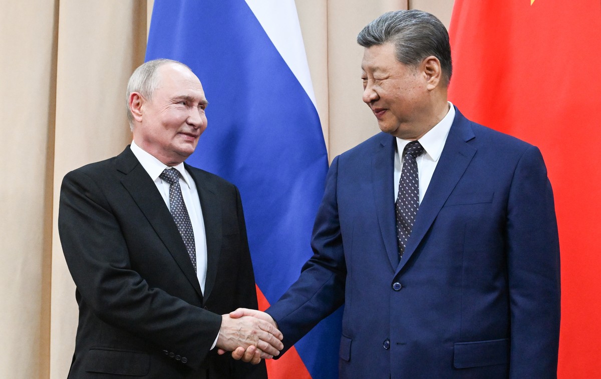 epa13202592 Russian President Vladimir Putin (L) and Chinese President Xi Jinping shake hands as they pose for photos before a meeting on the sidelines of the Shanghai Cooperation Organization (SCO) s ...