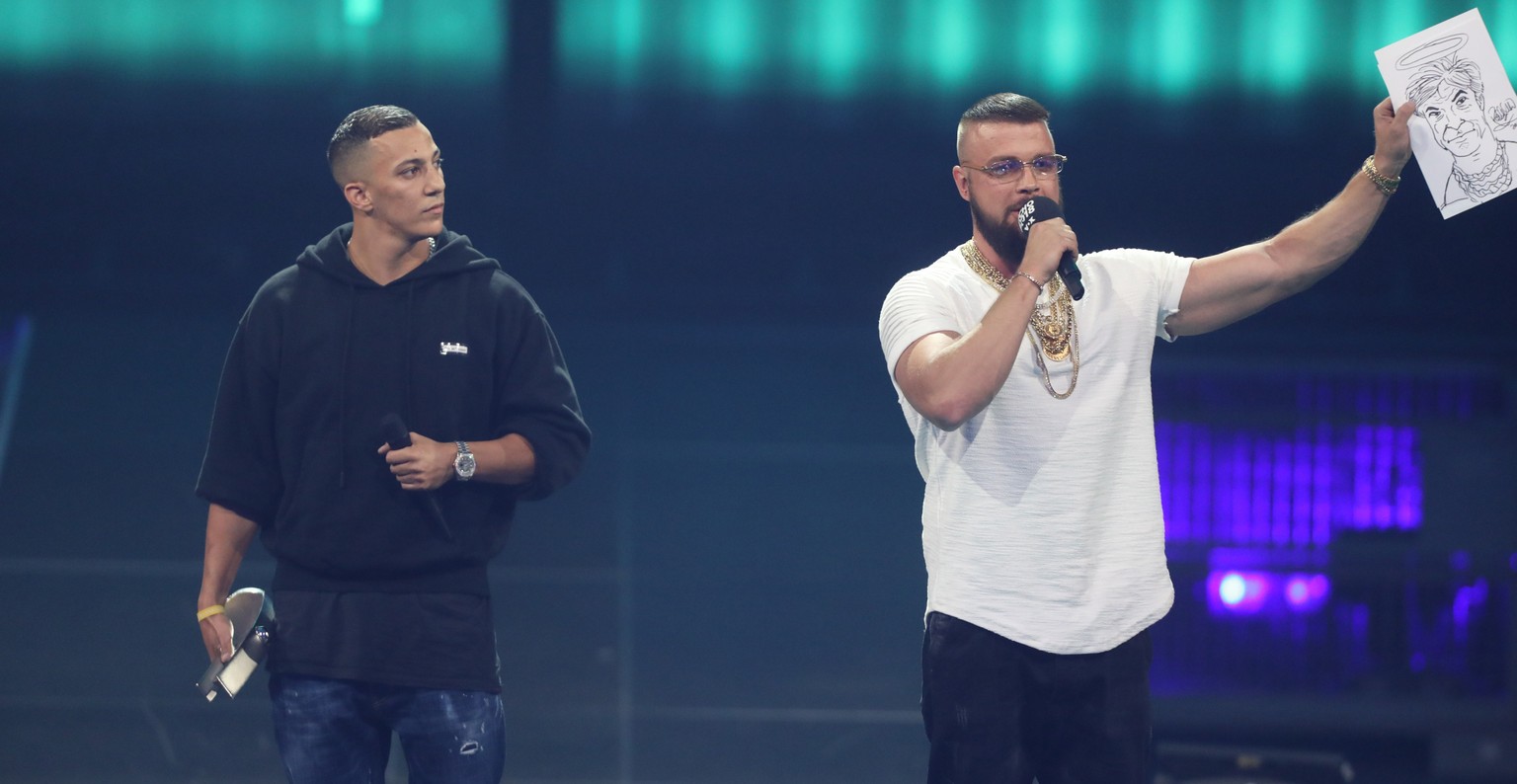 12.04.2018, Berlin: Kollegah (r) und Farid Bang erhalten den Echo Hip-Hop/Urban National bei der 27. Verleihung des Deutschen Musikpreises Echo. Die Rapper halten eine Karrikatur von Sänger Campino mi ...