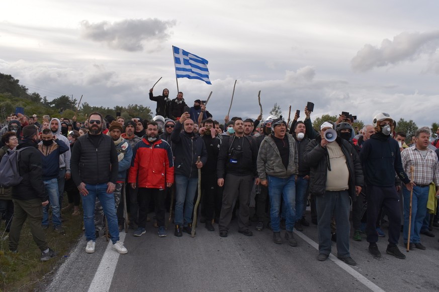 epa08250621 Protesting residents of Mantamados village face riot police forces outside their village, Lesvos Island, Greece, 26 February 2020. People protest against the presence of riot policemen on  ...