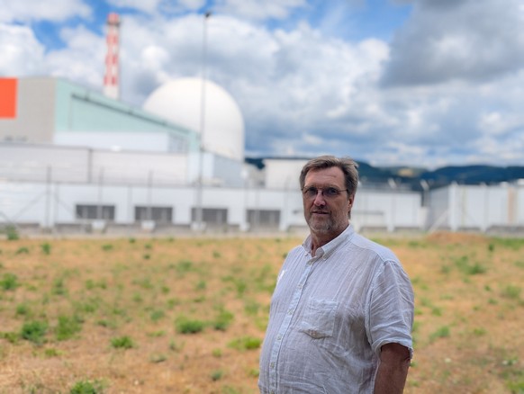 Jürg Joss vor dem «Schrottreaktor» und dem Hochkamin auf dem Gelände des AKW Leibstadt