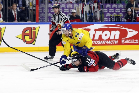 Sweden&#039;s Elias Lindholm, top, challenges for the puck with Canada&#039;s Mike Matheson during the Ice Hockey World Championships final match between Canada and Sweden in the LANXESS arena in Colo ...