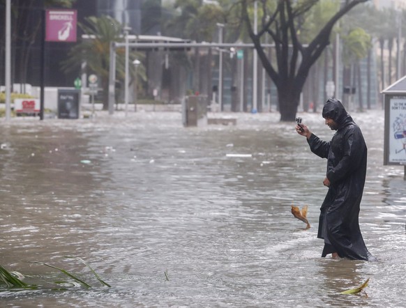 epa06197175 Peter Moodley documents the storm surge flood waters along Brickell Avenue after the full effects of Hurricane Irma struck in Miami, Florida, USA, 10 September 2017. Many areas are under m ...