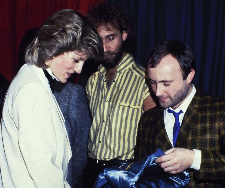 FILE - In this file photo dated Feb. 1984, Britain&#039;s Princess Diana talks with rock group &quot;Genesis&quot; with Mike Rutherford, centre, and Phil Collins, right, in February 1984. The Princess ...