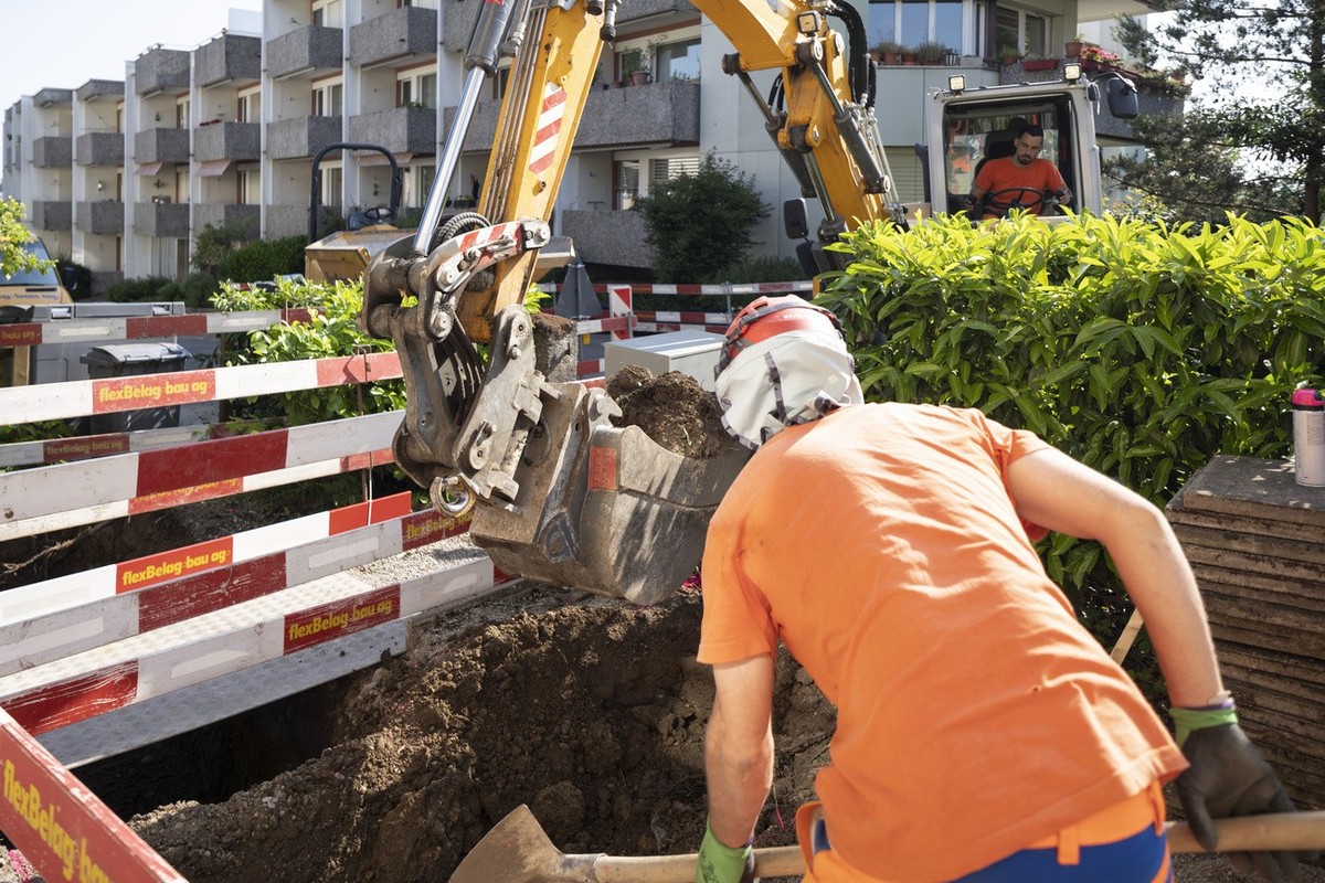 Bauarbeiter baggern einen Graben vom Haus zu den Fernwaermeleitungen, fotografiert am Mittwoch, 7. Juni 2023 in Zuerich. Die Stadt Zuerich will bis 2040 klimaneutral sein und hat die Strategie "n ...