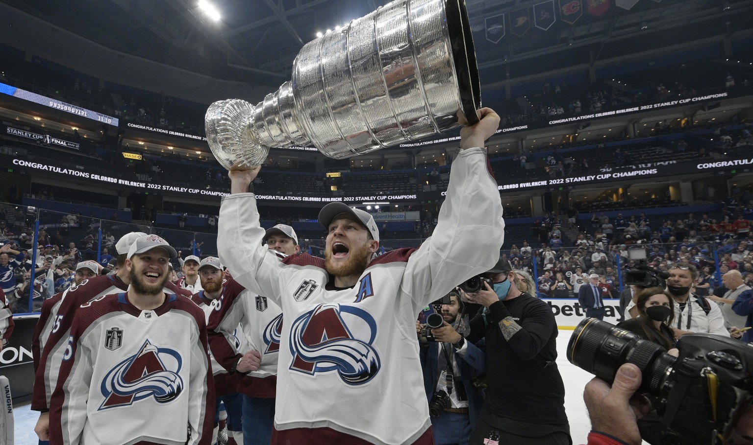 Colorado Avalanche center Nathan MacKinnon lifts the Stanley Cup after the team defeated the Tampa Bay Lightning in Game 6 of the NHL hockey Stanley Cup Finals on Sunday, June 26, 2022, in Tampa, Fla. ...