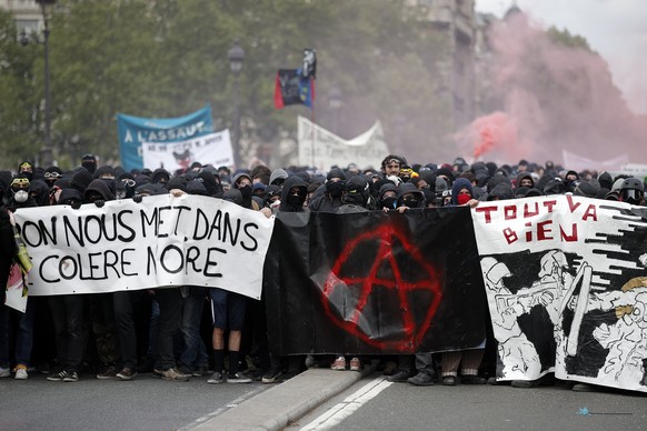 epa06705102 Masked youths protesters carry banners during a march ahead of clashes with French riot police forces during a demonstration of workers from the private and public sectors as well as labor ...