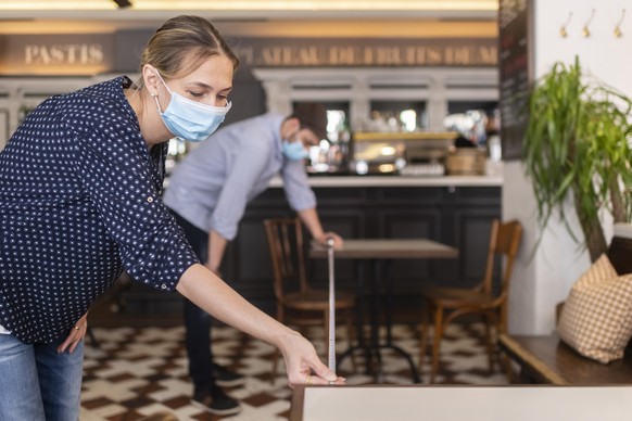 Peter und Jennifer messen den Abstand zu den Tischen anlaesslich der Wiederoeroeffnung ihres Restaurants &quot;Brasserie Louis&quot; am Montag, aufgneommen am Samstag, 9. Mai 2020 in Zuerich. (KEYSTON ...