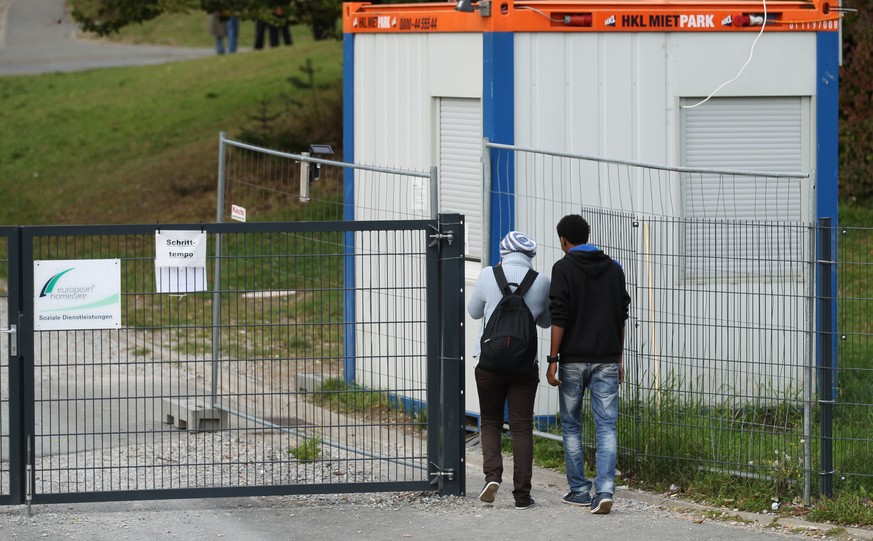 Refugees enter on September 29, 2014 a refugee center created on the site of the former barracks in Burbach, Germany. German police Monday investigated four private security guards accused of abusing  ...