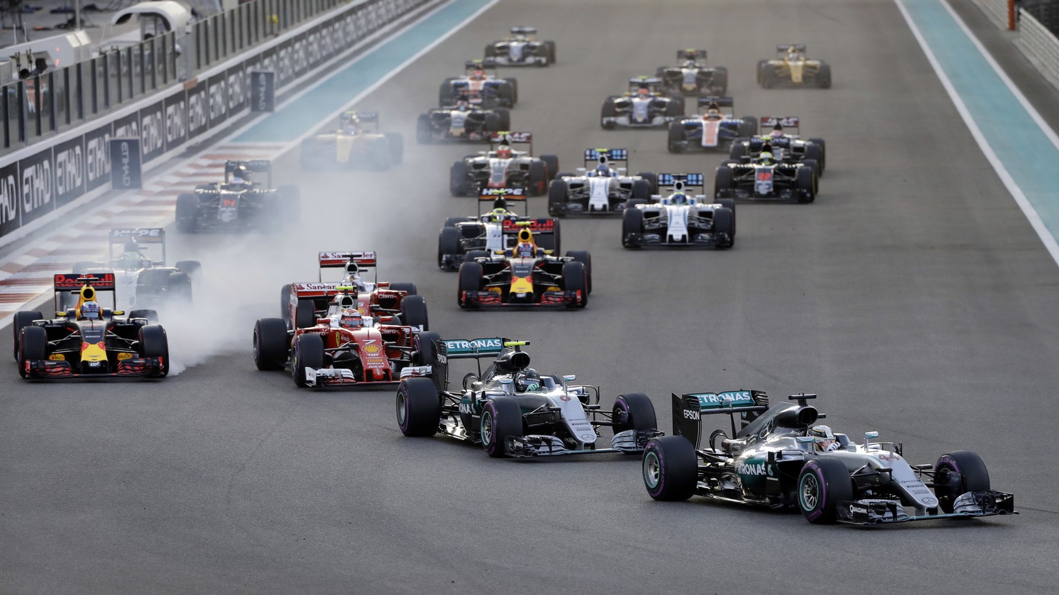 Mercedes driver Lewis Hamilton of Britain, right, leads teammate Mercedes driver Nico Rosberg of Germany at the start of the Emirates Formula One Grand Prix at the Yas Marina racetrack in Abu Dhabi, U ...
