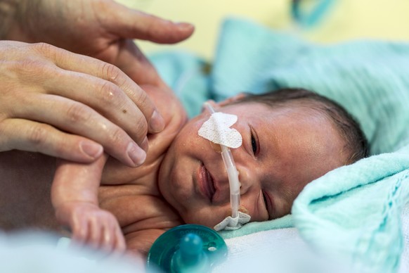 A mother gives her premature baby an oil massage after changing its nappy, pictured on August 15, 2013, at the neonatology intensive care ward of Zurich&#039;s University Hospital in Zurich, Switzerla ...