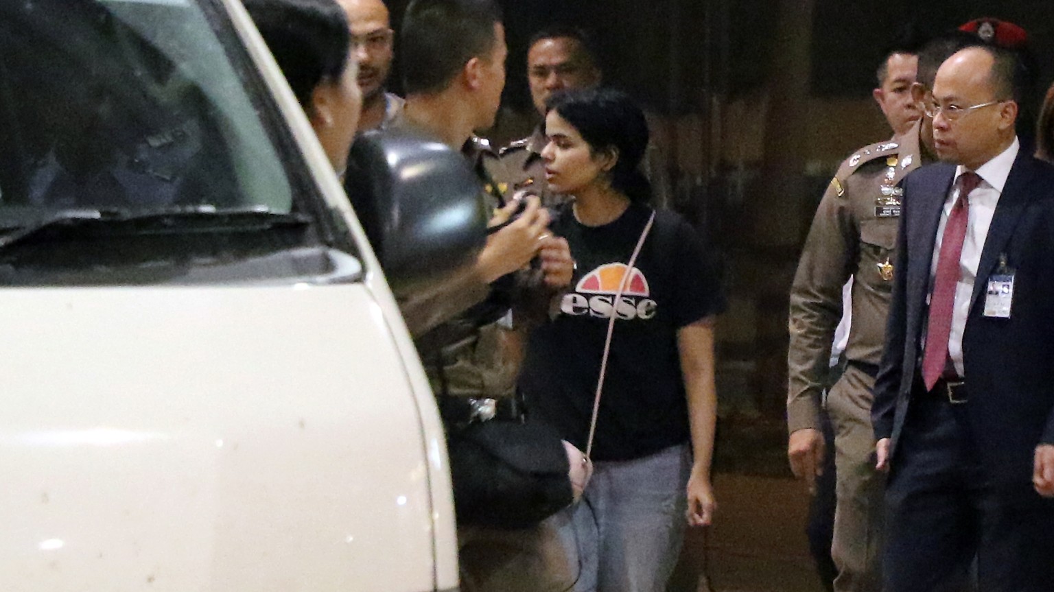 epaselect epa07267840 Saudi Arabia teenager Rahaf Mohammed al-Qunun (C) leaves as Thai police escorts her from the hotel at Suvarnabhumi international airport in Samut Prakan province, on the outskirt ...