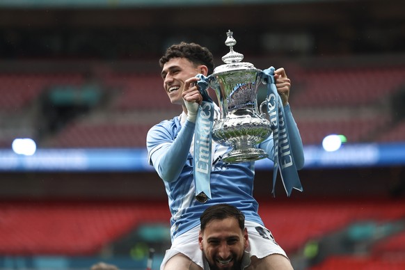 epa12964829 Manchester City's goalkeeper Gianluigi Donnarumma (down) and Phil Foden (top) celebrate with the cup after winning the English FA Cup final match Chelsea FC against Manchester City, i ...