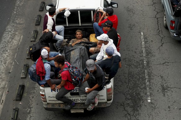 epa07102186 Honduran migrants travel in the back of a truck to the department of Escuintla to approach the border with Mexico leaving the Casa del Migrante shelter in Guatemala City, Guatemala, 18 Oct ...