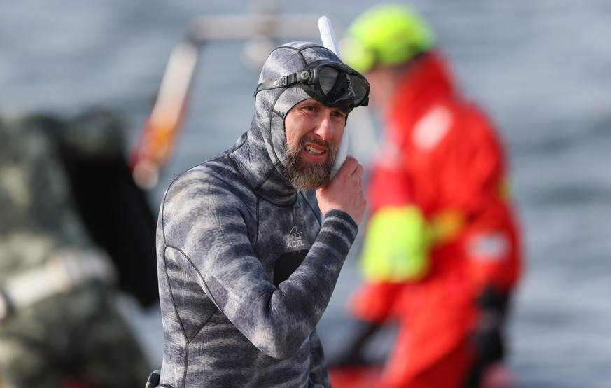 epa12850227 Marine biologist Robert Marc Lehmann prepares to dive to a beached whale lying in the waters of the Baltic Sea near Niendorf harbor in Timmendorfer Strand, Germany, 26 March 2026. The hump ...