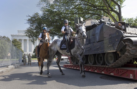 epa07692190 Mounted US Park Police pass by an armored Bradley Fighting Vehicle near the Lincoln Memorial as preparations continue for the US Independence Day celebrations on the National Mall in Washi ...
